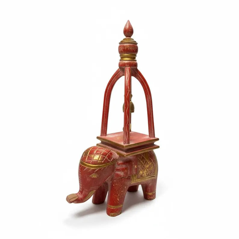 Decorative red elephant figurine with gold accents on a white background