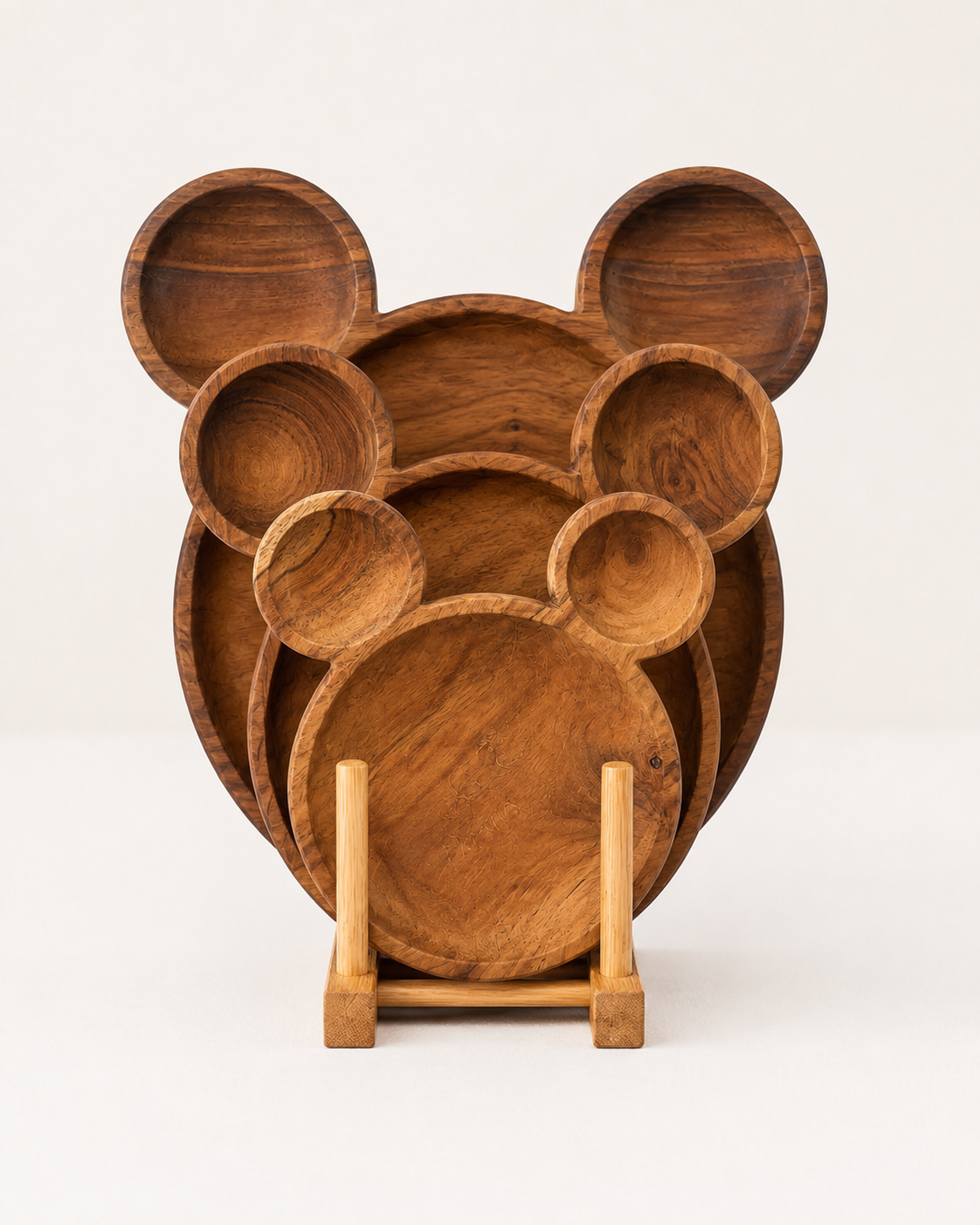 A set of wooden plates shaped like a mouse head, displayed on a small wooden stand against a clean white background.