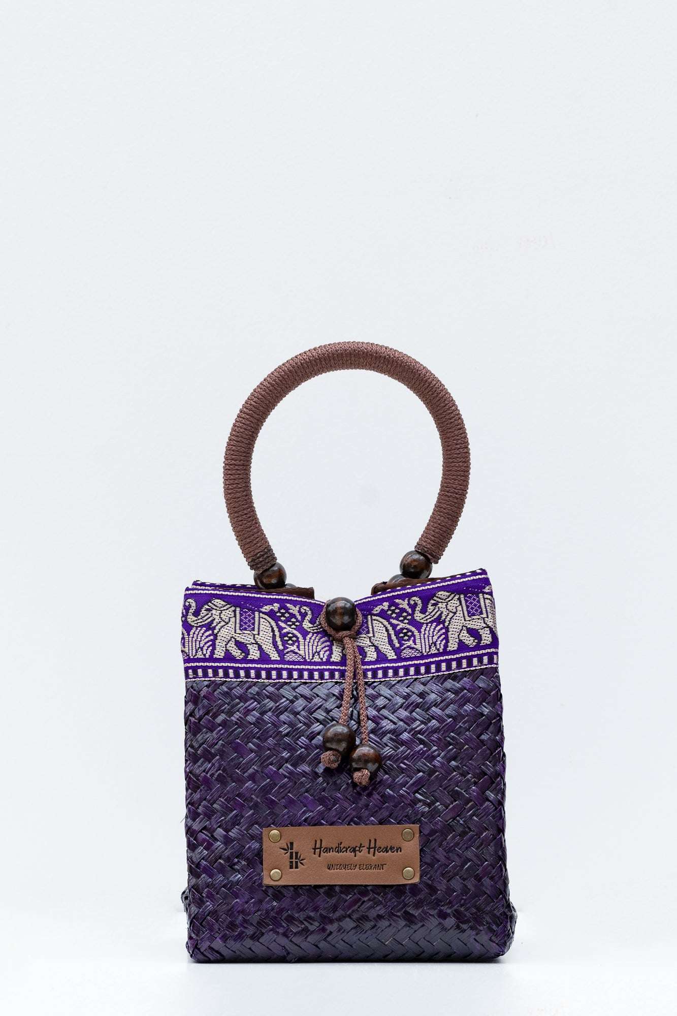 Purple woven handbag with brown handle and elephant design on a white background