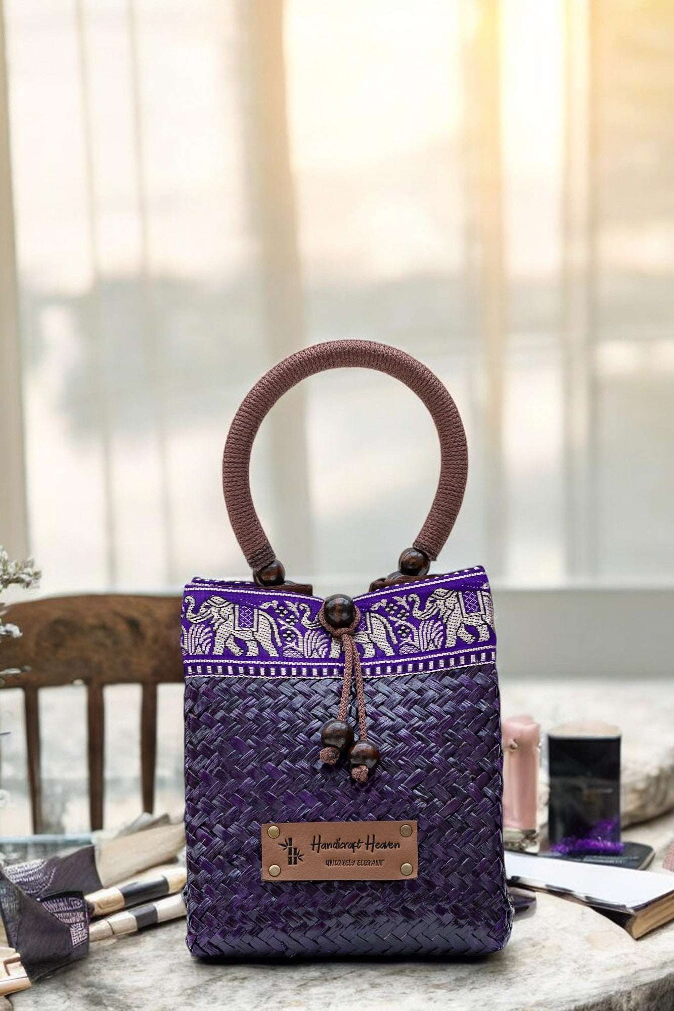 Purple woven handbag with elephant patterns on a table