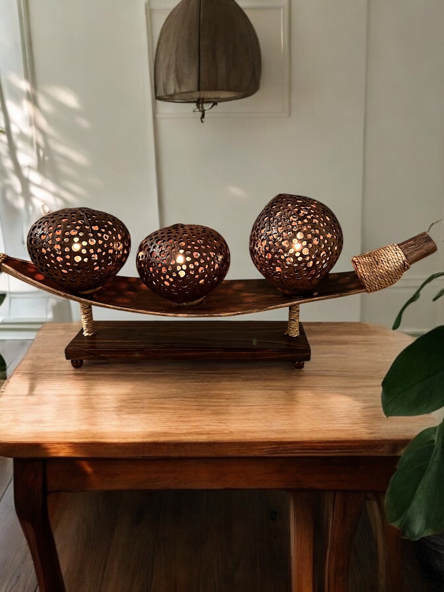 Decorative coconut shell table lamp with spherical metal shades on a wooden stand