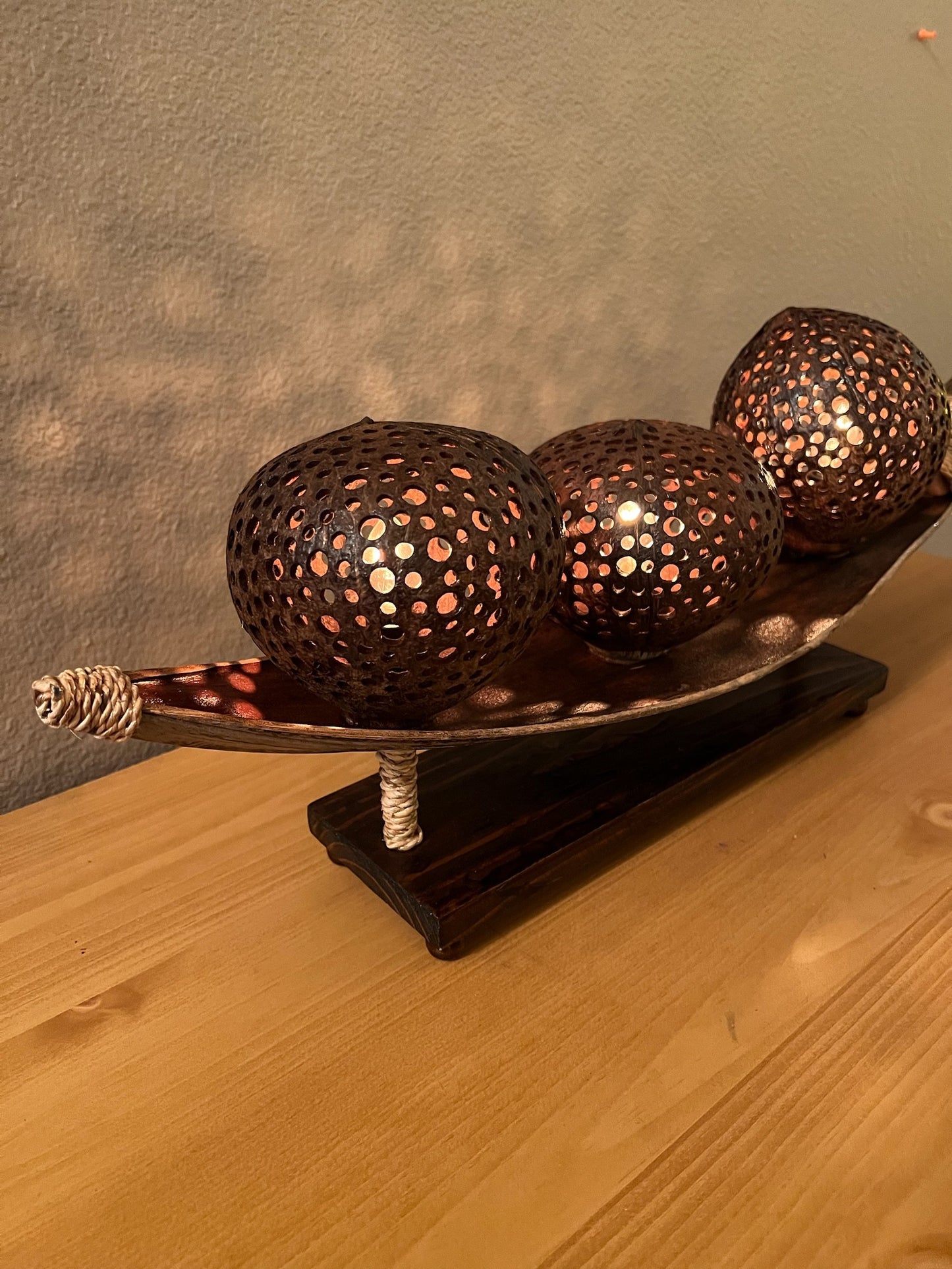 Decorative coconut shell table lamp on a stand against a neutral background