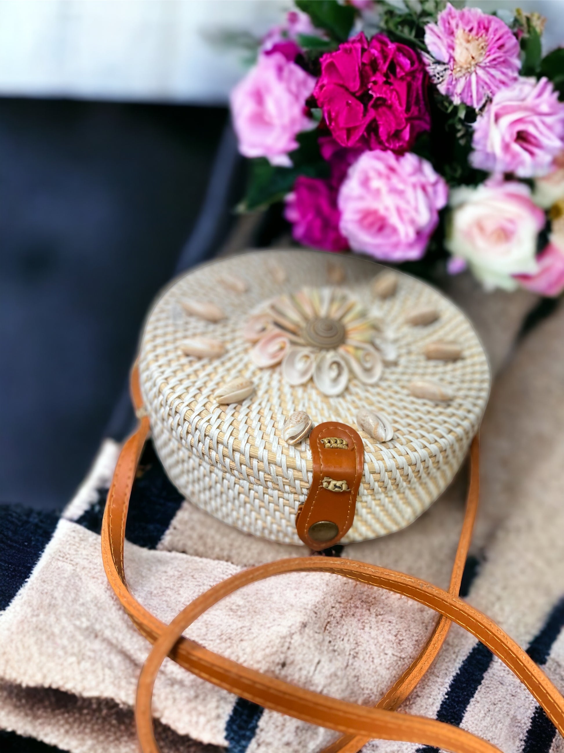 Woven handbag with a sea shell floral arrangement in the background