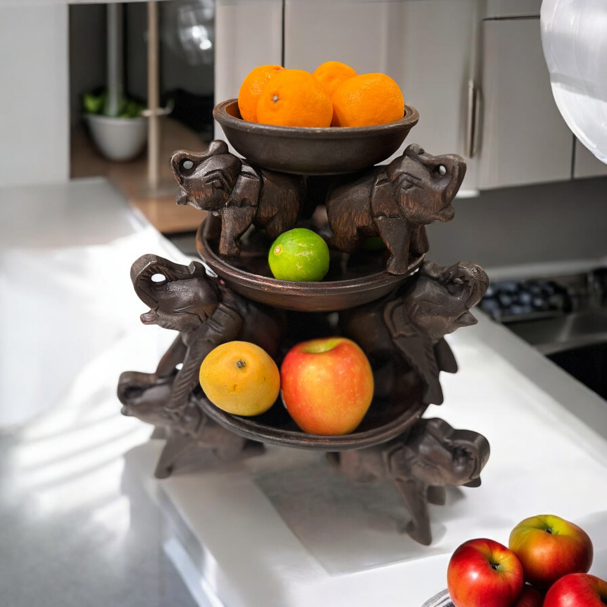 Decorative Triple Elephant Round Wood Tray Stand with fruits on a kitchen counter