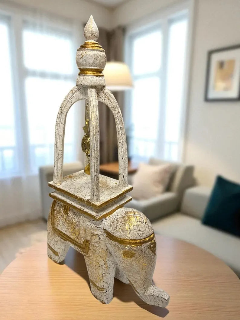 Decorative elephant decor with bells and gold accents on a table in a living room setting