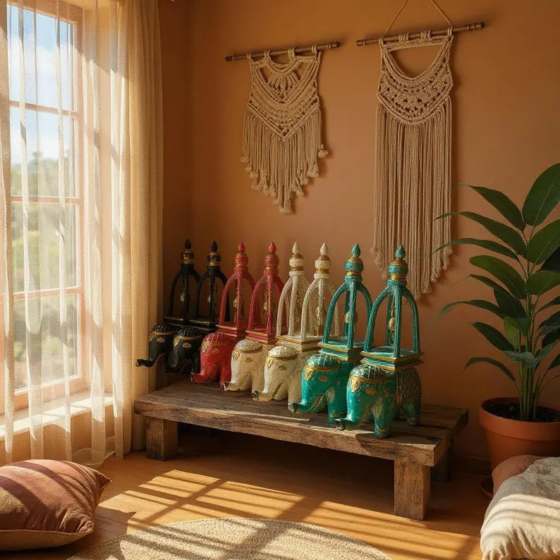Decorative elephant figurines on a wooden bench with macrame wall hangings in a warm-toned room.
