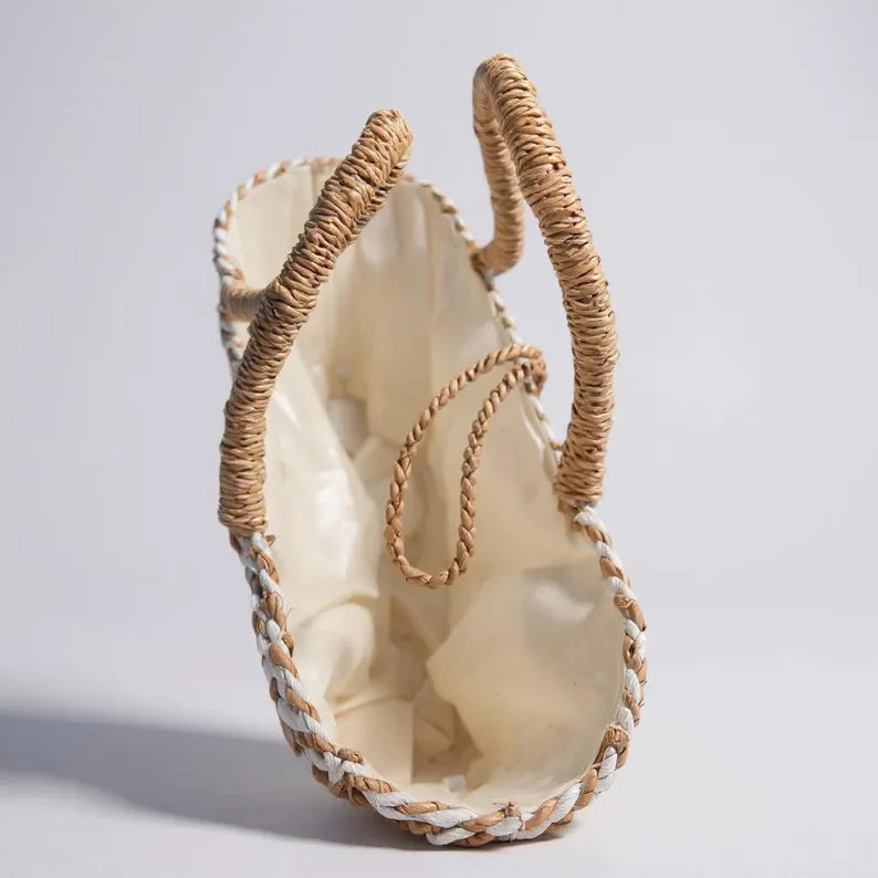 Beige woven handbag with natural handle on a light gray background