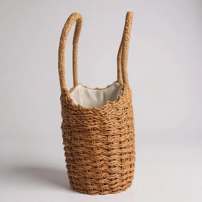 Woven basket with handles on a light gray background