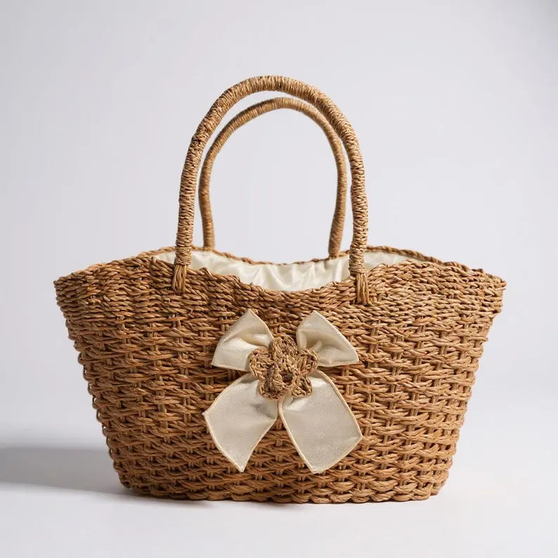 Woven handbag with a decorative bow on a light gray background