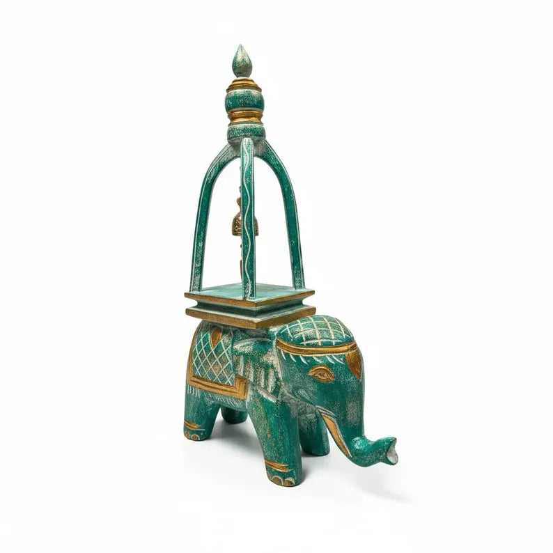 Decorative teal elephant with a small pagoda on a white background