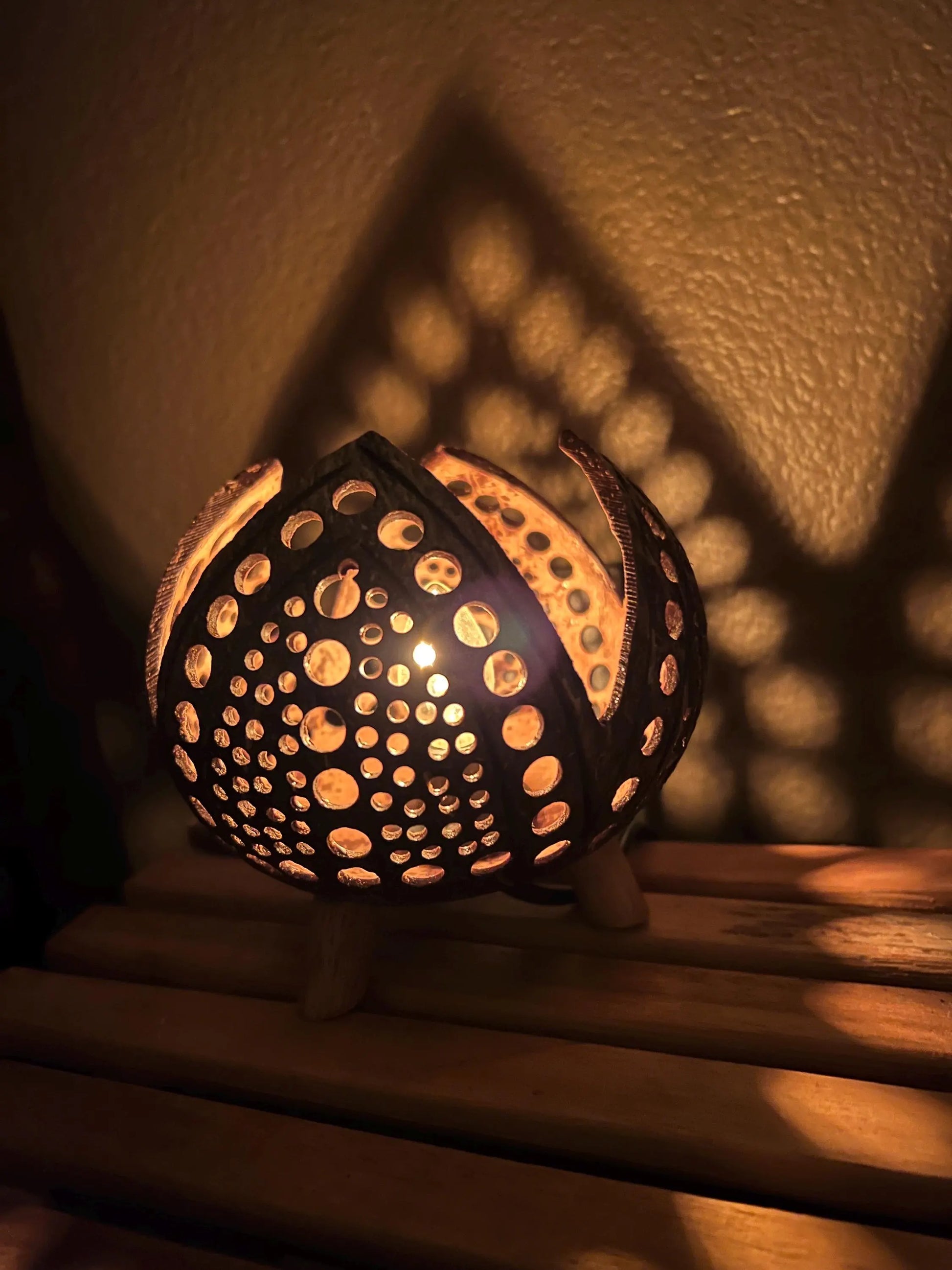 Decorative Coconut Shell Lamp with intricate design on a wooden surface