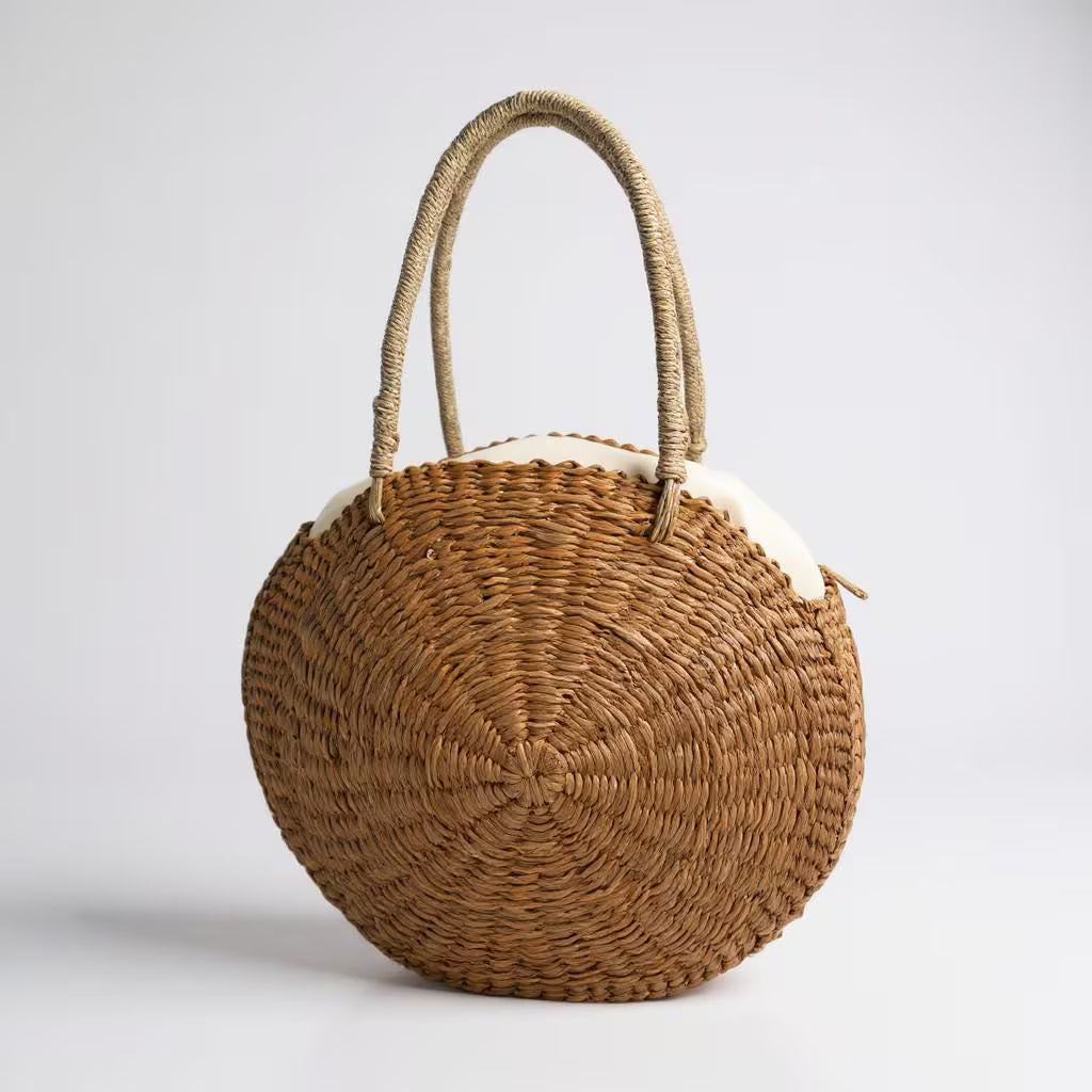 Round woven bag with a handle on a light gray background