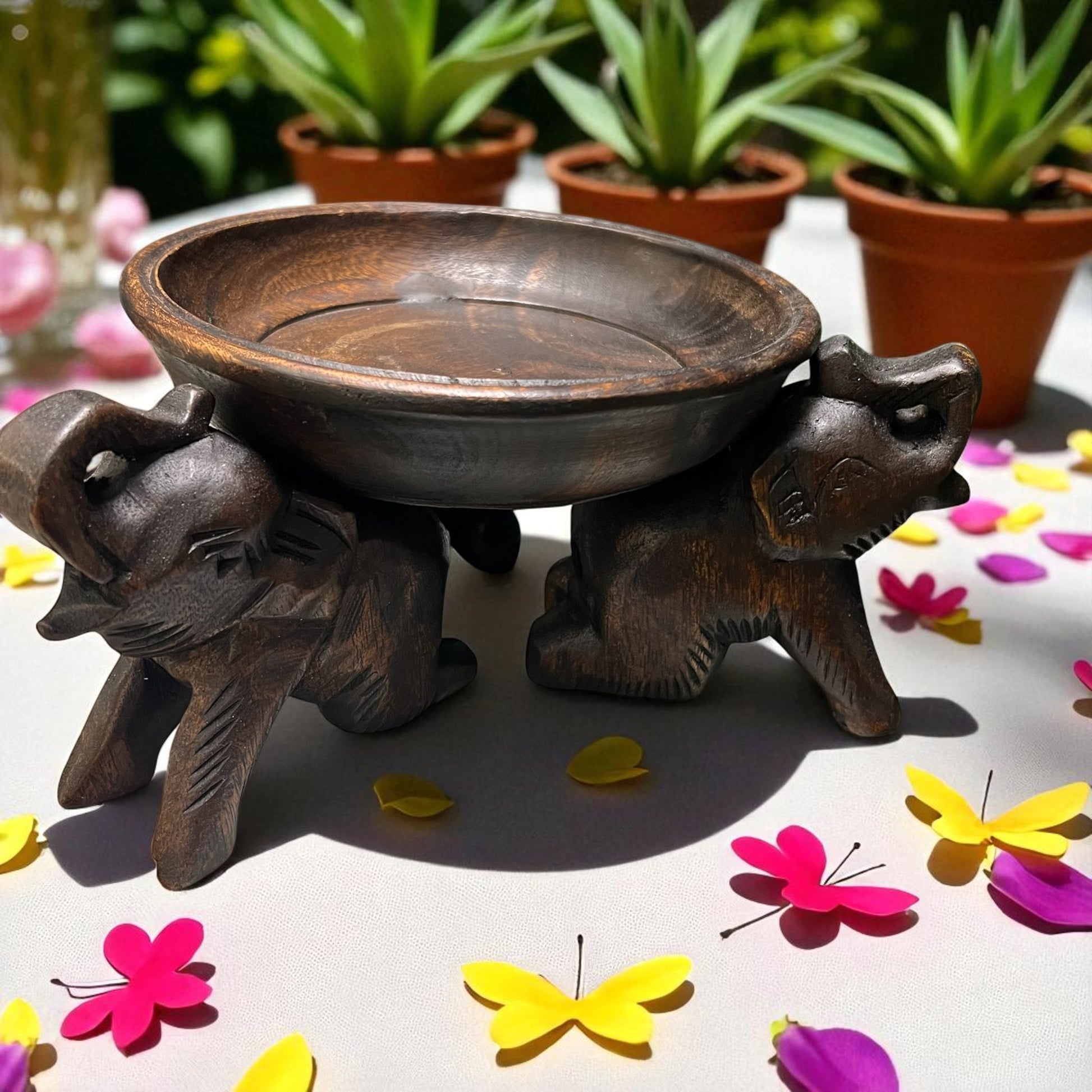 Triple Elephant Round Wood Tray Stand on a surface with colorful butterflies and flowers.