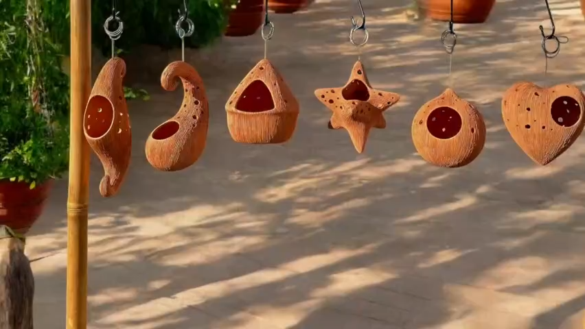 Decorative Terracotta pots hanging outdoors on a wooden post.